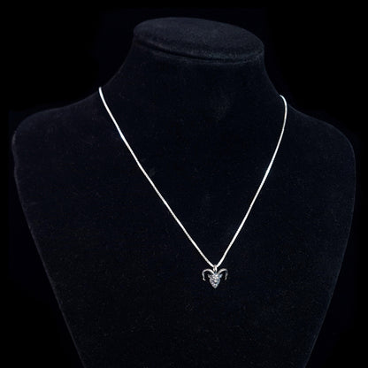 RBZ Jewelry Gothic Sterling Horned Demon pendant displayed on a black velvet neck mannequin to show how the piece hangs when worn. The small, oxidized sterling silver demon head with its signature snarling expression and curved horns is suspended from a bright silver chain against a solid black background.