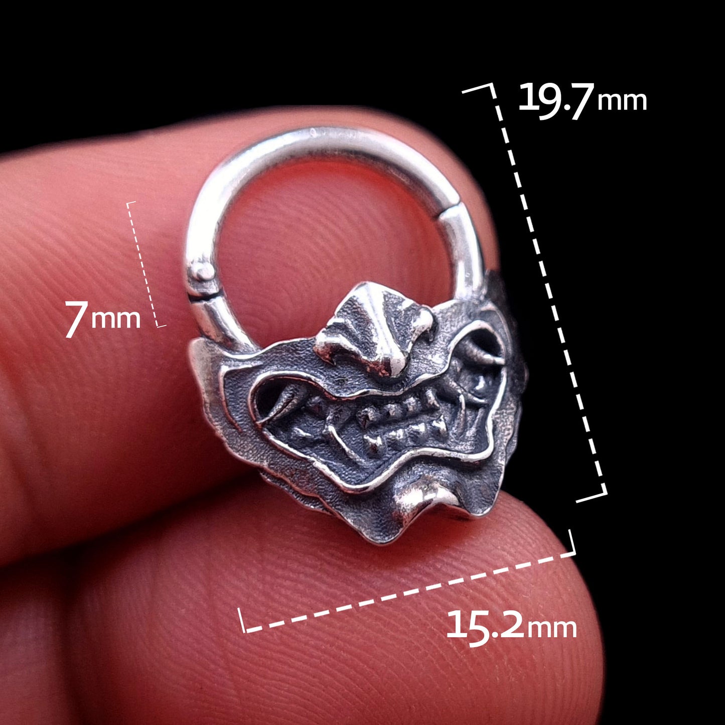 Sterling silver Samurai Oni mask septum ring by RBZ Jewelry, held in hand with overlaid dimensions showing a 7mm inner drop, 19.7mm total height, and 15.2mm width.