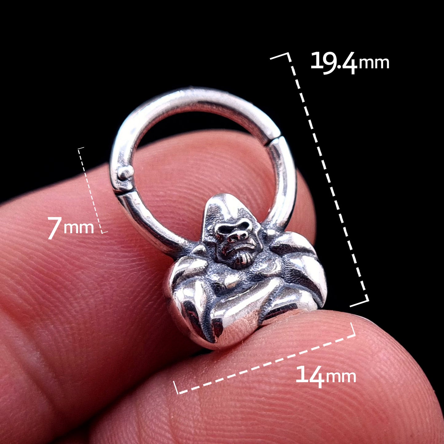 Front view of the sterling silver Jungle Gorilla septum clicker ring by RBZ Jewelry held in a hand, featuring dimension overlays: 19.4mm total height, 14mm width, and 7mm inner drop.
