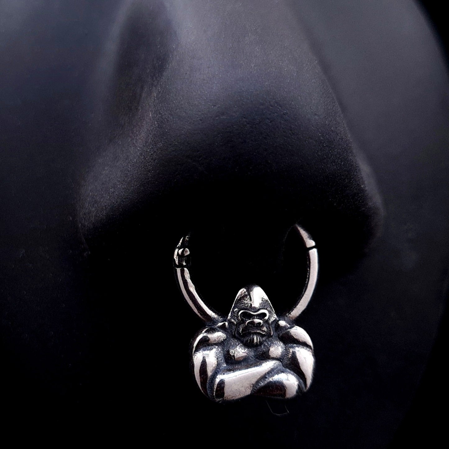 Sterling silver Jungle Gorilla septum clicker ring by RBZ Jewelry shown worn on a life-size black silicone nose display, illustrating the placement and fit of the detailed gorilla bust design.