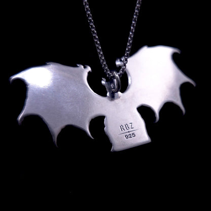 A detailed photograph of the reverse side of the RBZ Jewelry Gothic Sterling silver Lilith Demon Angel pendant, displaying a smooth, mirror-polished surface on the back of the enthroned figure and the expansive bat wings. Stamped clearly onto the back of the central body are the official RBZ hallmark and the '925' sterling silver purity mark. A sterling silver chain is attached at the top loop, with the pendant set against a deep black background.