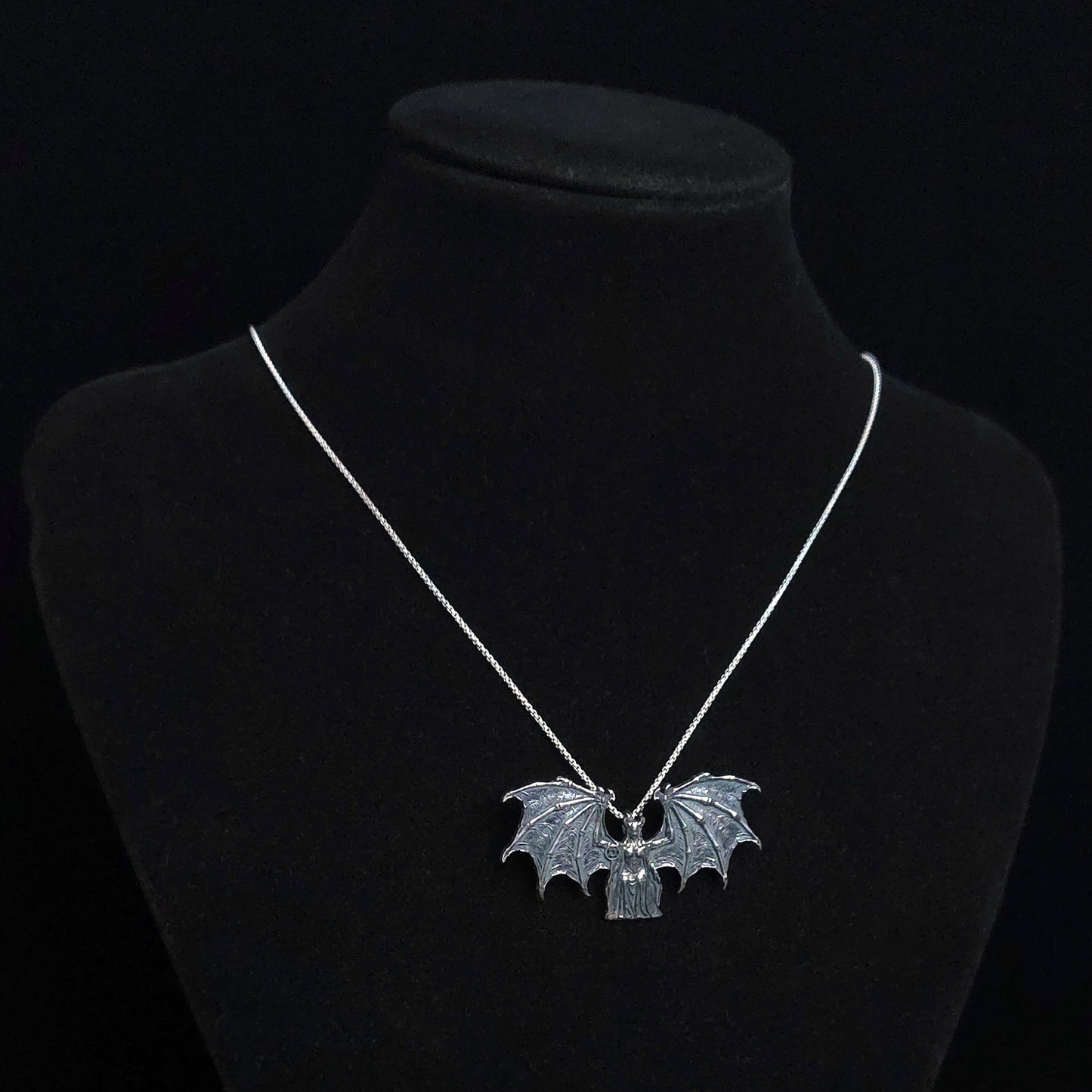 RBZ Jewelry Gothic Judaica Sterling silver Lilith Demon Angel pendant with skeletal bat wings, displayed on a black mannequin bust to show scale and drape on a silver chain.