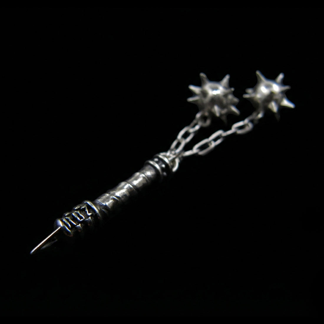 Side view of the Sterling silver Flail Crusher pendant by RBZ Jewelry, highlighting the engraved RBZ logo on the handle base and two sharp spiked spheres on chains in a gothic medieval style.