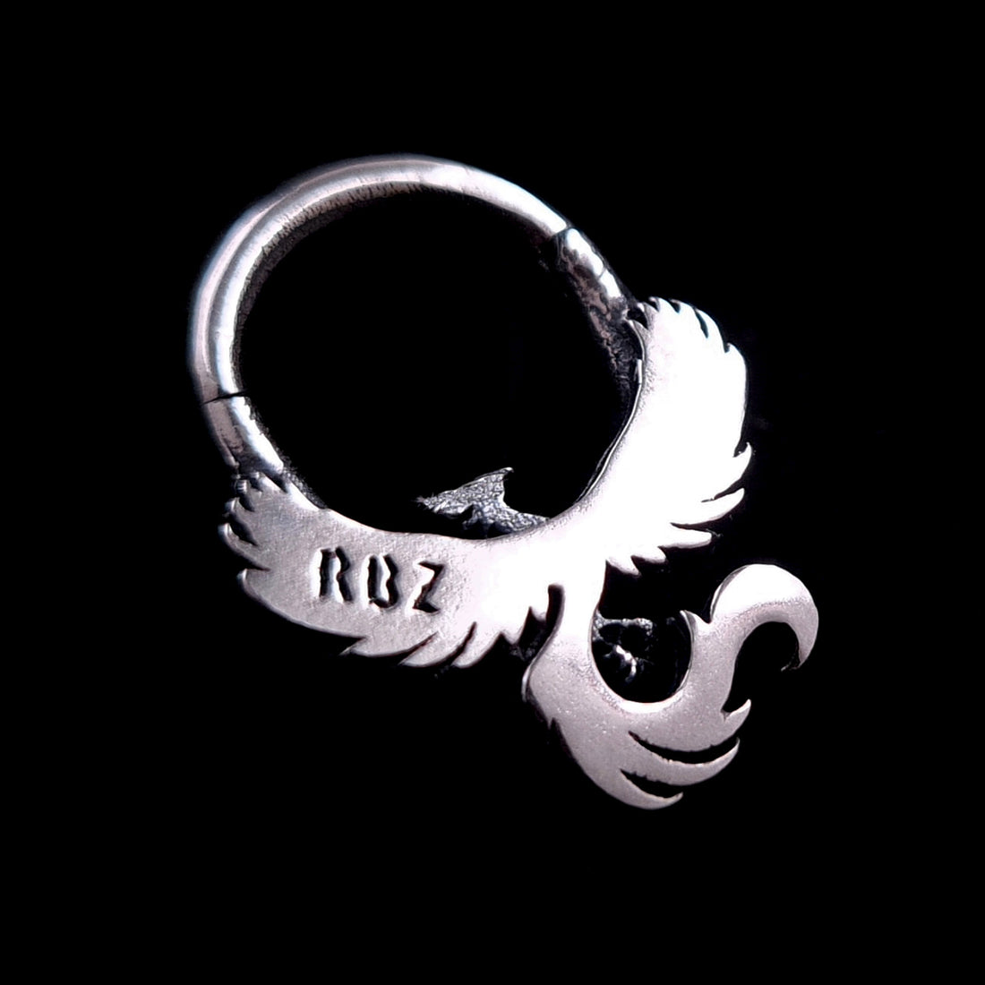 Back view of the sterling silver Soaring Phoenix septum ring by RBZ Jewelry, showing the smooth polished finish and the official RBZ maker's mark stamped on the wing, isolated on a black background.
