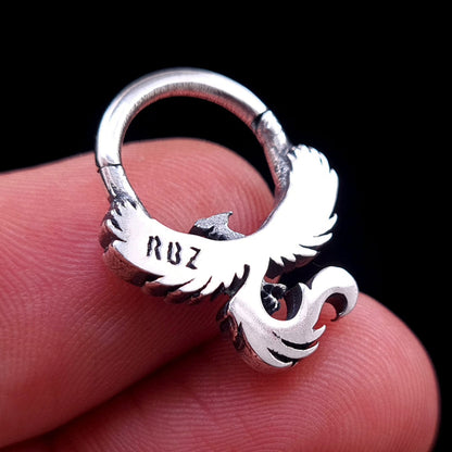 Close-up back view of the sterling silver Soaring Phoenix septum ring from RBZ Jewelry, held between fingertips to show scale and the smooth, polished back surface with the prominently stamped 'RBZ' maker's mark against a black background.
