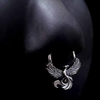 Sterling silver Soaring Phoenix septum ring by RBZ Jewelry displayed on a life-size black silicone nose mannequin, showcasing the anatomical fit and the bold, unrestrained aesthetic of the intricately carved phoenix design.