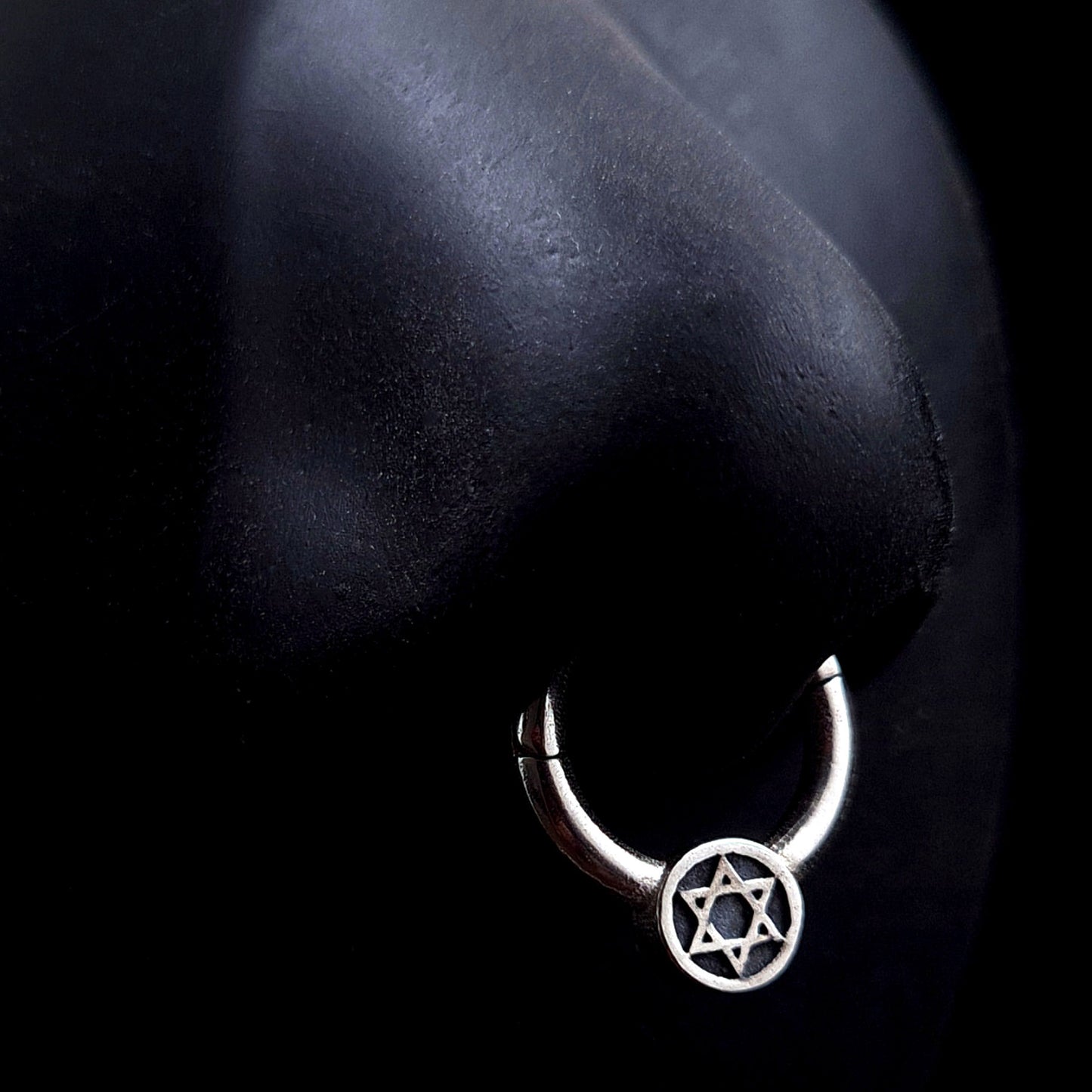 Sterling silver Star of David septum clicker ring by RBZ Jewelry, shown worn on a life-size black silicone nose model to demonstrate fit, scale, and aesthetic.