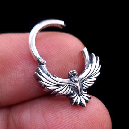Sterling silver Tribal Eagle septum ring by RBZ Jewelry held in hand, showing the clicker hinge in the open position to highlight the functional design and intricate eagle detail.
