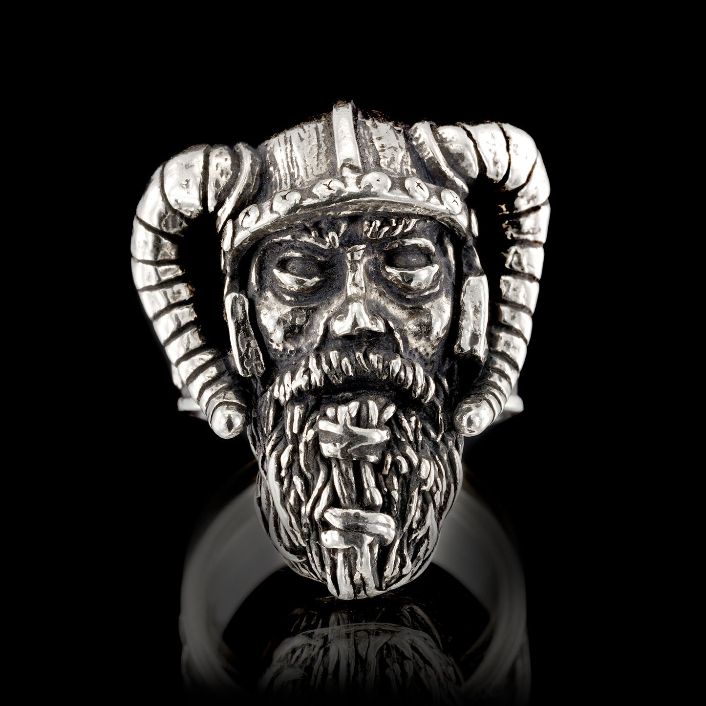 Full frontal view of the Sterling silver Viking warrior ring by RBZ Jewelry, showcasing the hand-sculpted weathered warrior face and detailed horned helmet on a black reflective background.