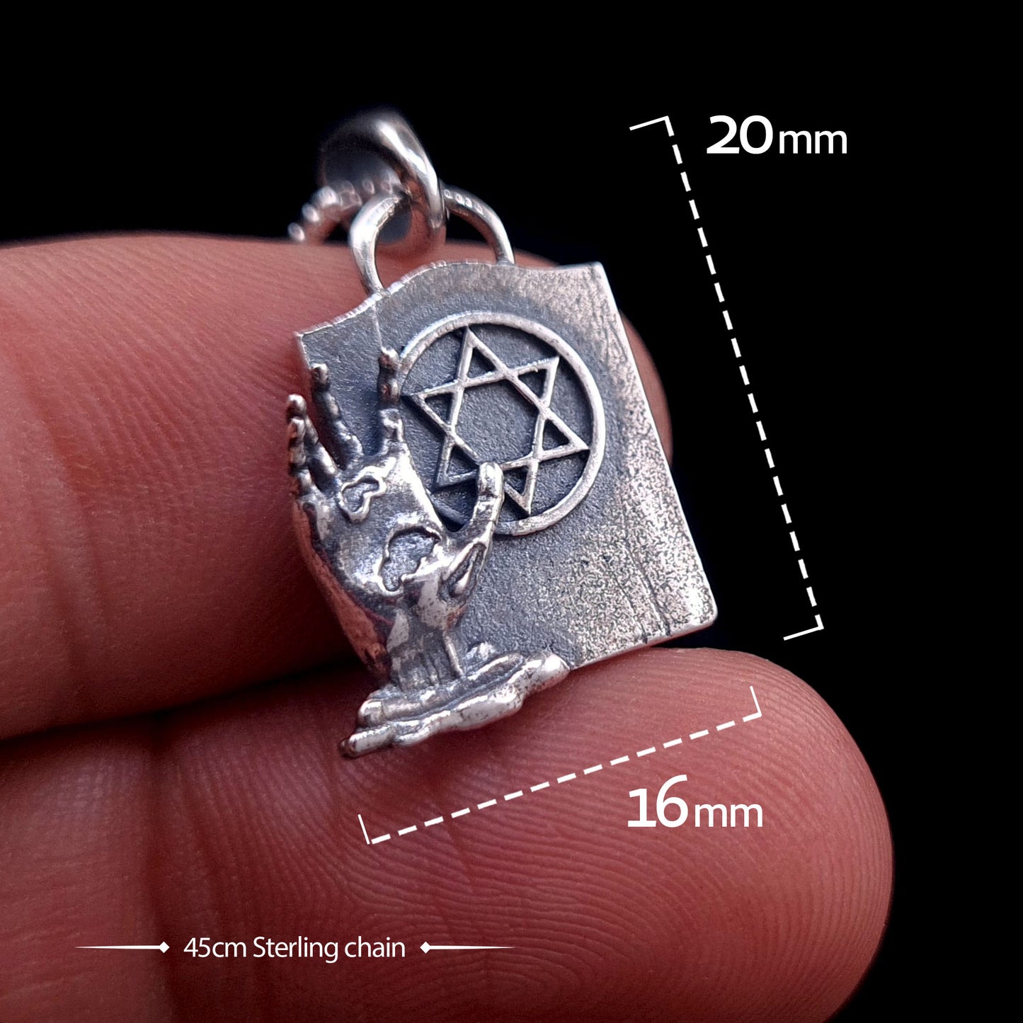 Sterling silver Gothic Zombie Star of David pendant held between fingers to demonstrate scale. Graphic overlays show dimensions of 20mm height and 16mm width, with a 45cm sterling silver chain. The pendant features a detailed zombie hand beside a tombstone with a Magen David symbol.