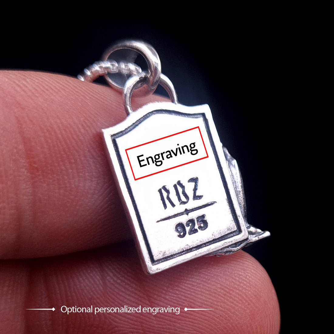 Back view of the sterling silver Zombie Star of David pendant held between fingers to demonstrate scale. The image highlights the RBZ logo, 925 hallmark, and a designated area for optional personalized engraving on the tombstone-shaped back.