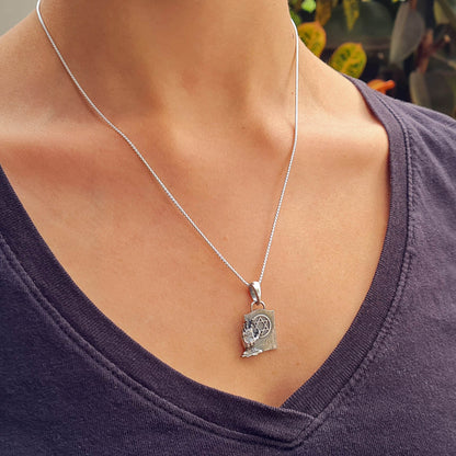 Lifestyle view of the sterling silver Gothic Zombie Star of David pendant worn by a female model on a 45cm chain. The macabre tombstone and decaying zombie hand pendant is displayed as a statement piece, illustrating its size and fit for daily wear, by RBZ Jewelry.